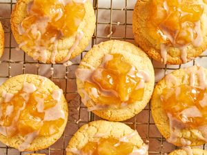 Baked cookies with an apple topping placed on a cooling rack