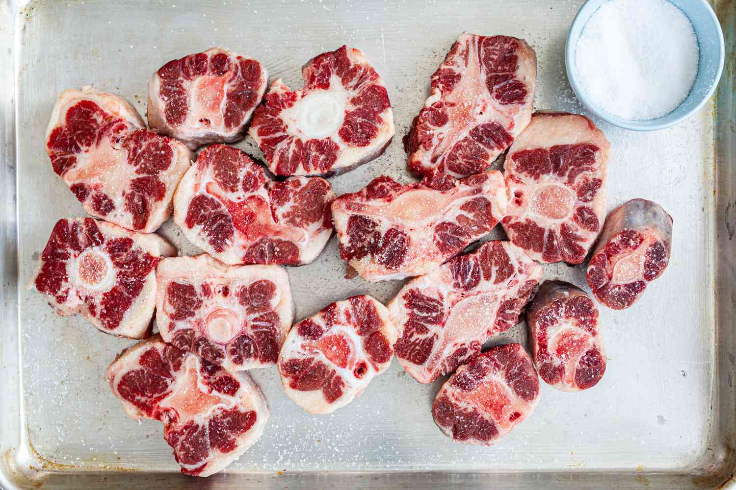 A baking sheet with chopped oxtails to make an oxtail recipe.