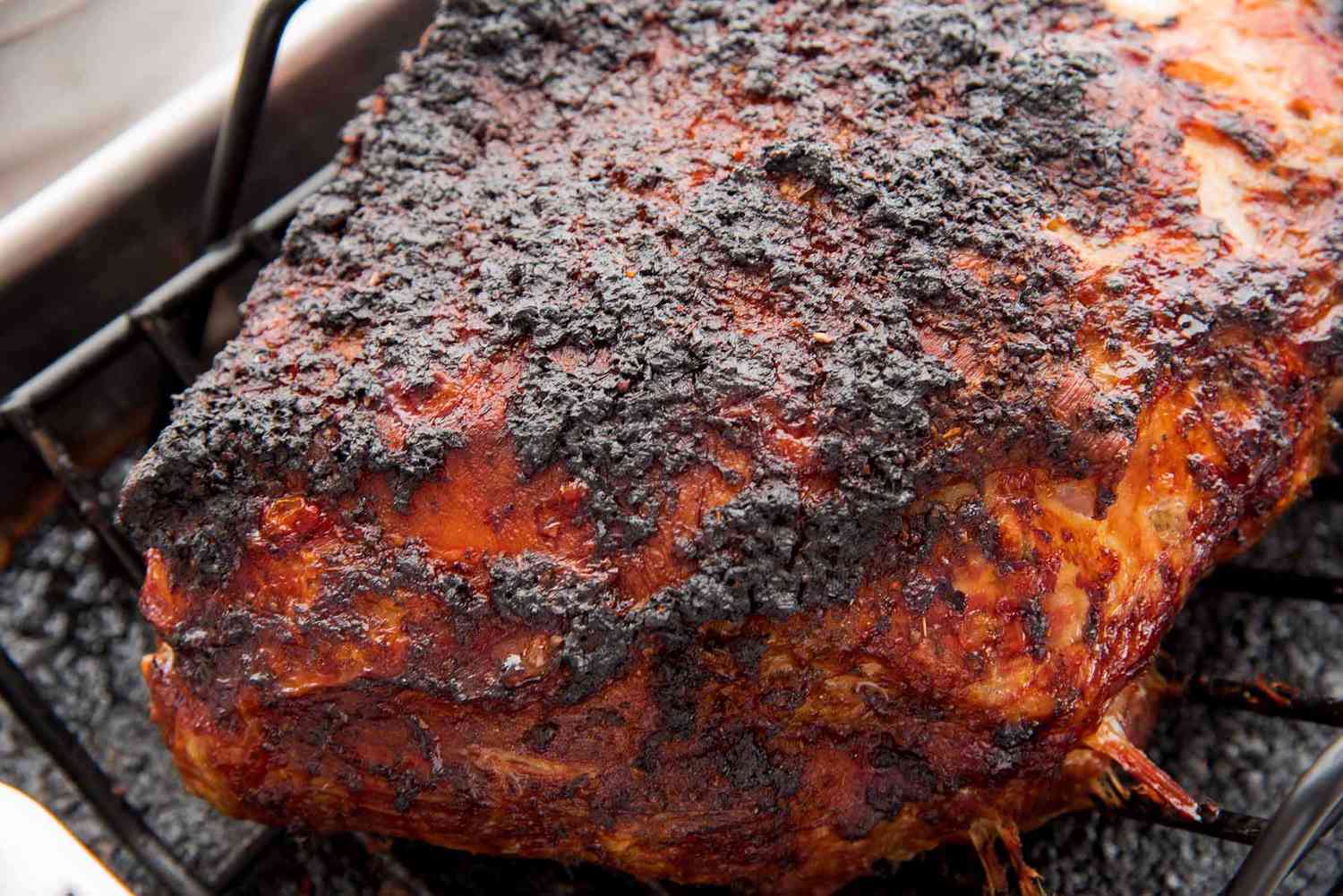Cuban-style pork roast with a crispy crust resting in a roasting pan.