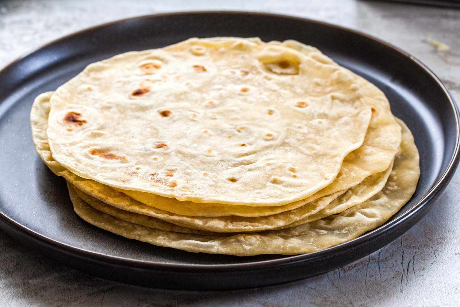 Homemade flour tortillas on a platter.