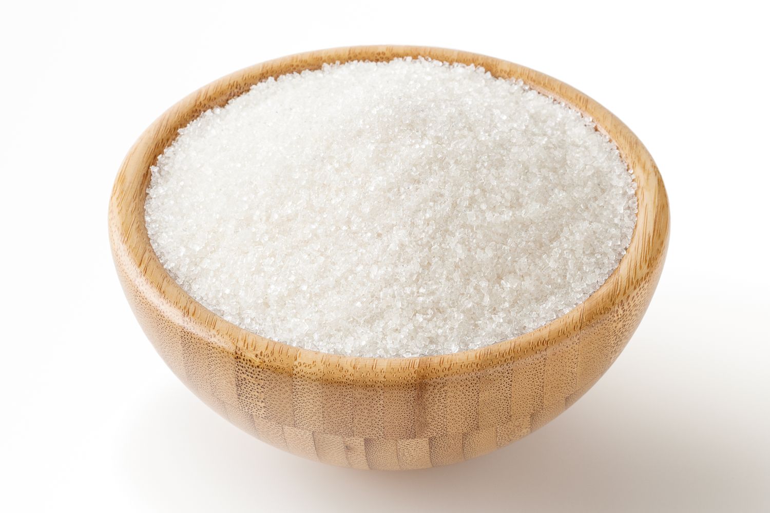 A wooden bowl filled with granulated sugar