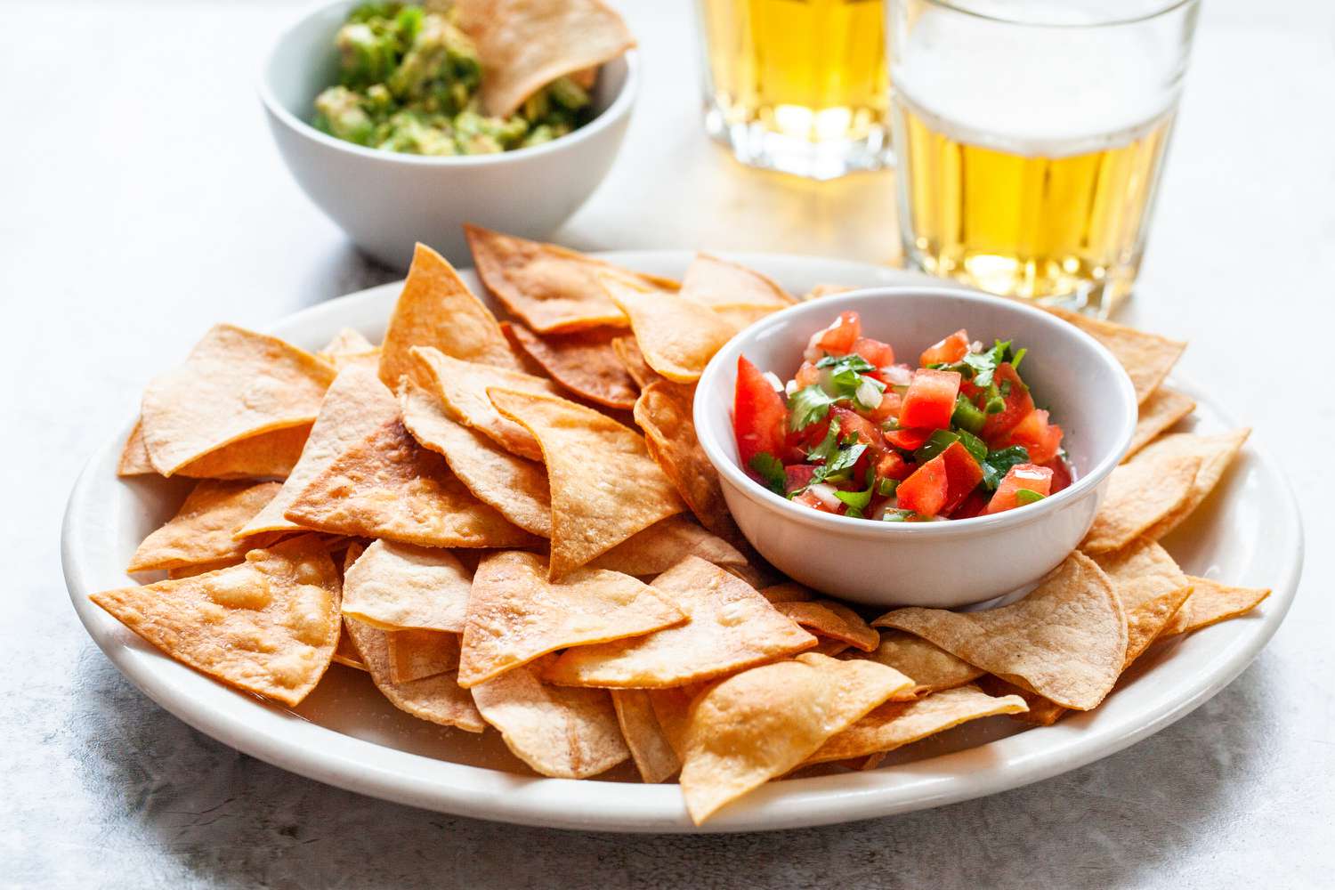 A platter of tortilla chips and salsa.