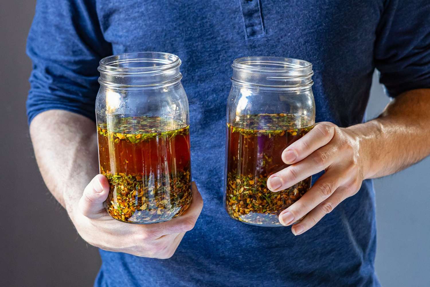 A person holding two mason jars to show how to make Campari.
