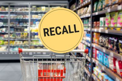 Shopping cart in a supermarket aisle with a recall sign displayed