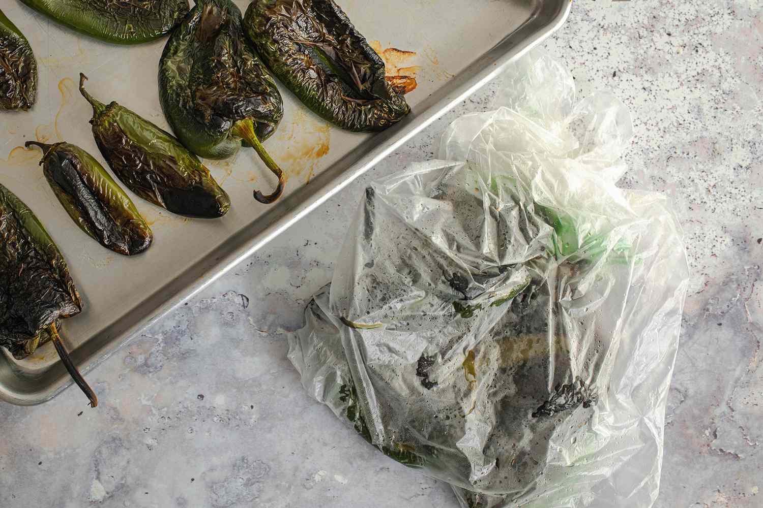 Roasted Peppers on a Tray and Some in a Plastic Bag for Poblano, Corn, and Cheese Tamales Recipe 