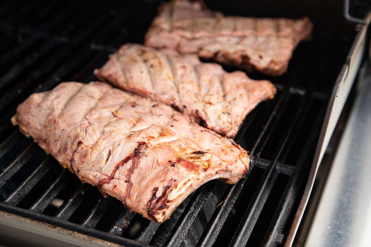 Grilling four racks of bbq ribs.