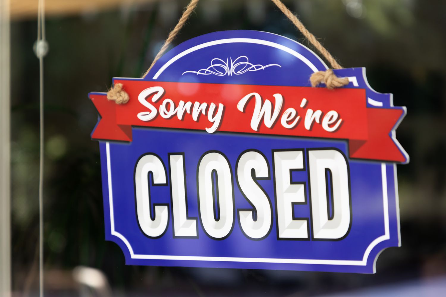A closed sign hanging on a glass door