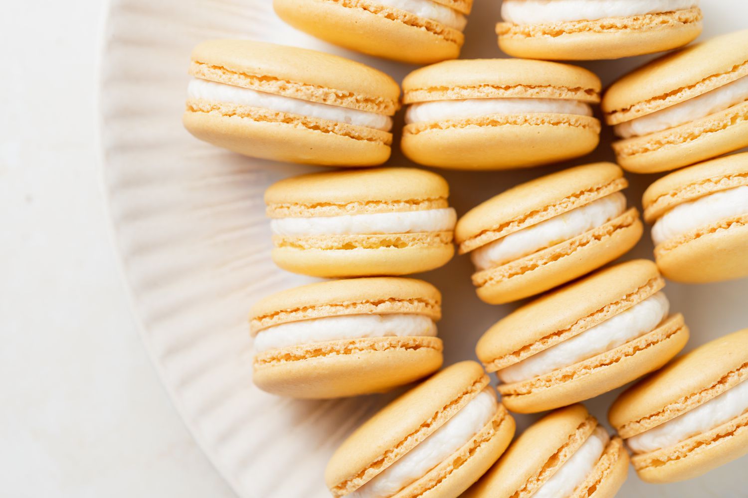 Overhead view of French macarons filled with lemon buttercream set on their side.