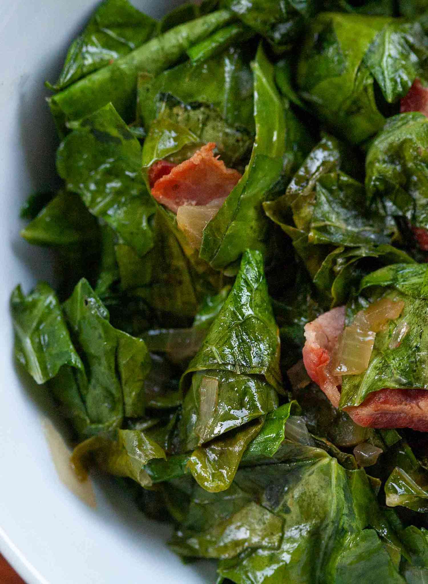 A bowl of collard greens with bacon