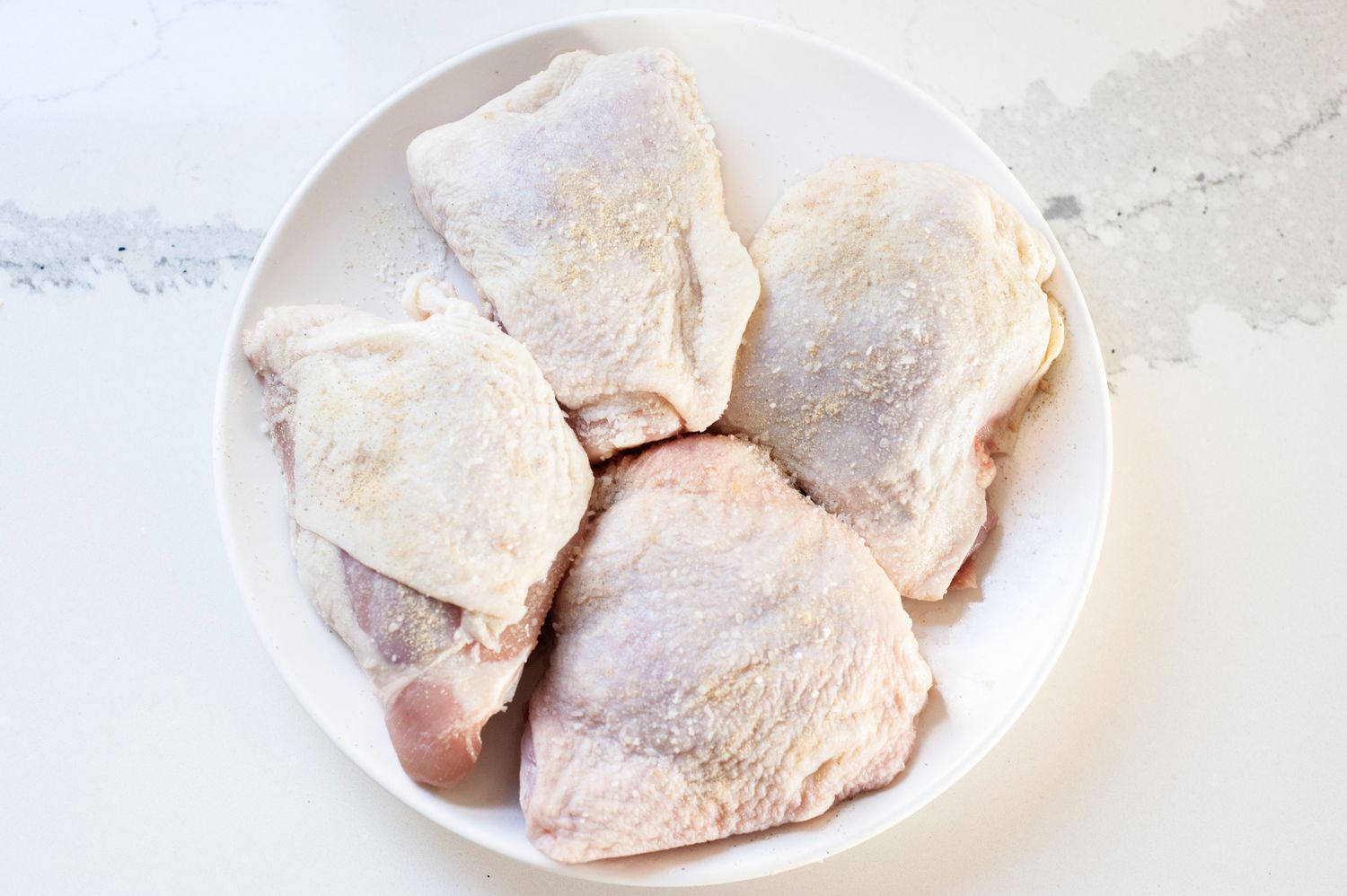 Seasoned Chicken Thighs on a Plate for Chicken Vesuvio Recipe