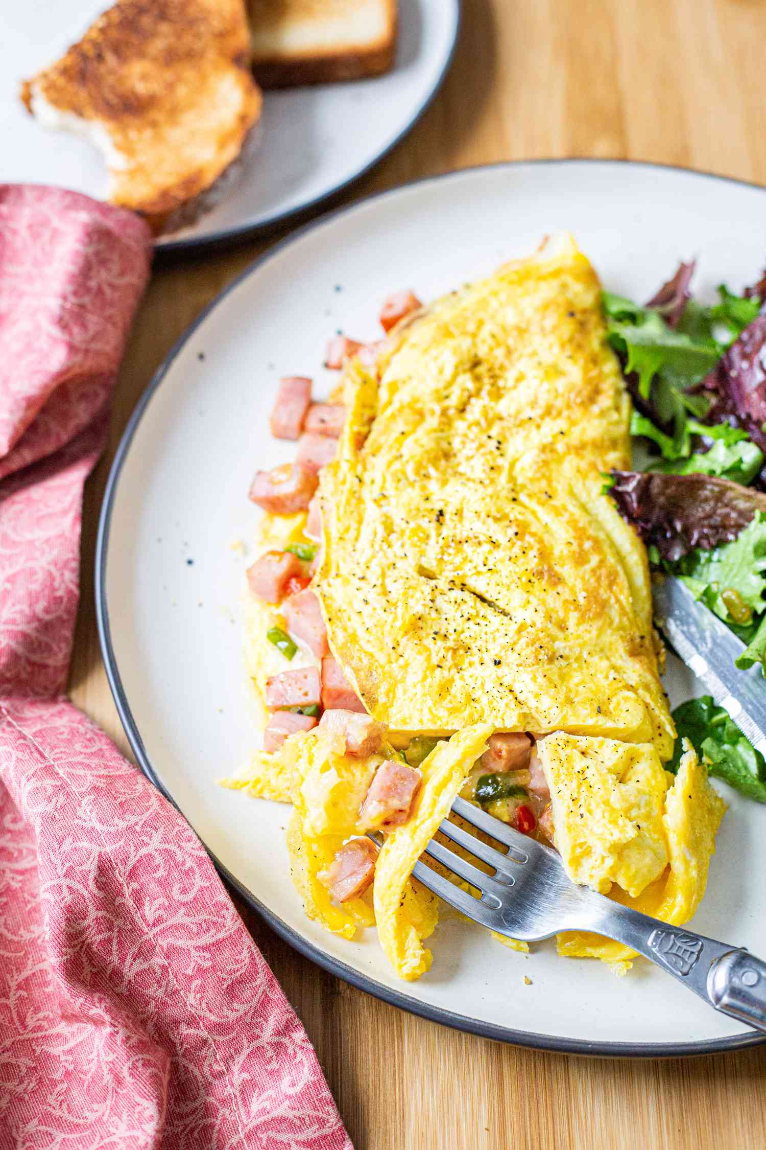 Denver Omelet with Mixed Greens on Plate with a Fork