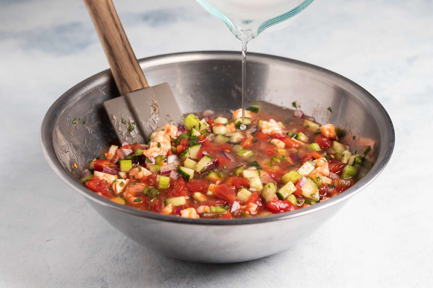 A mixing bowl with ingredients to make a shrimp cocktail recipe.