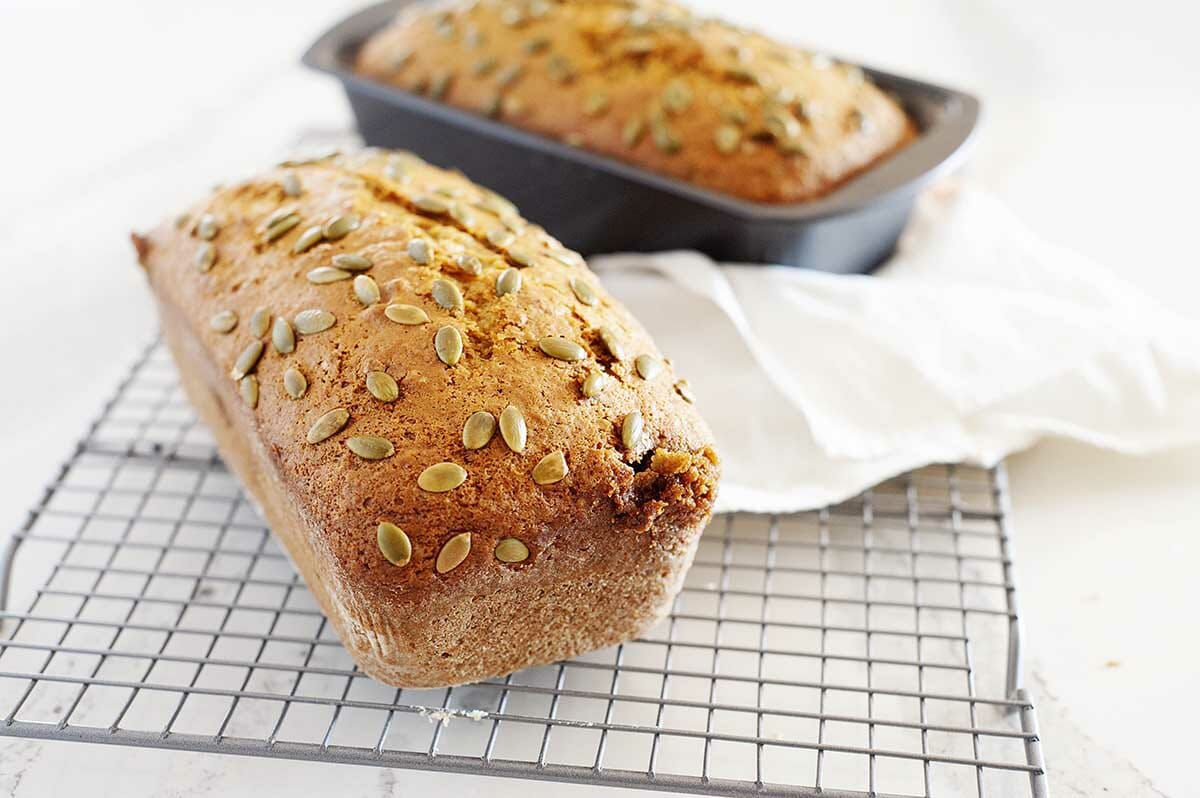 Two loaves of vegan pumpkin bread on a cooling rack