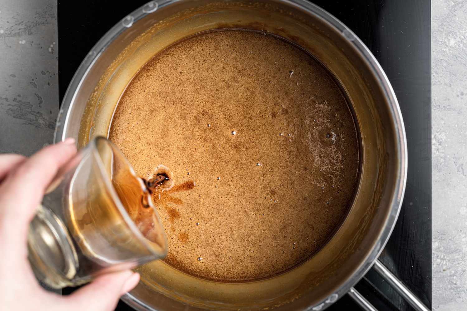 Adding vanilla extract for pecan praline candy