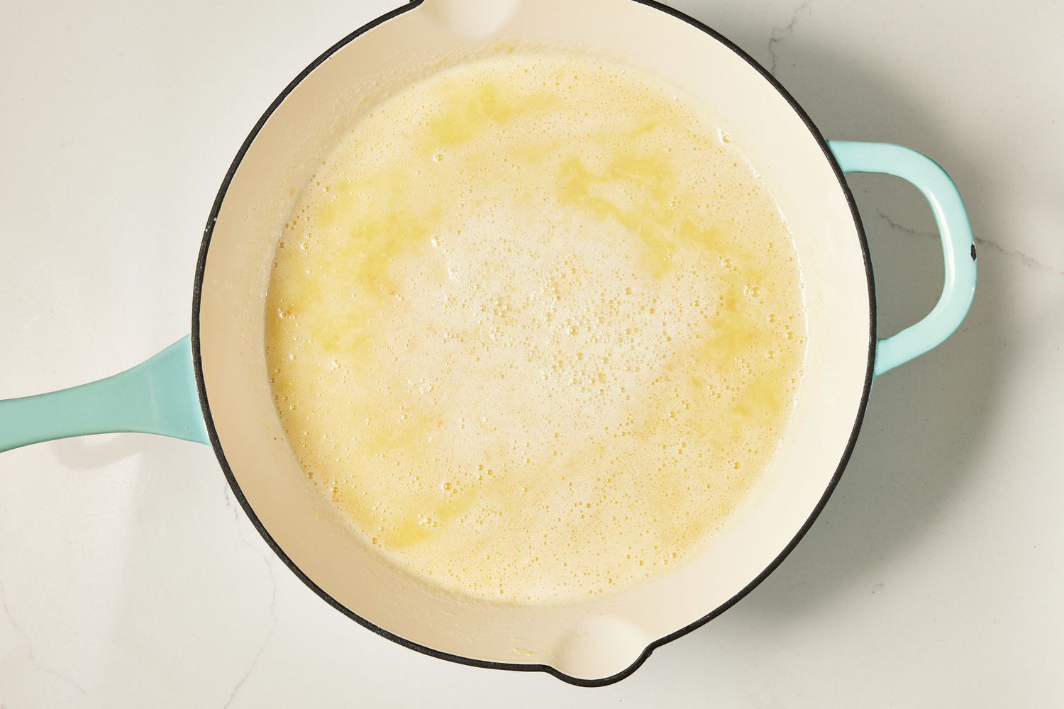 Melted butter and flour mixture bubbling in a skillet for copycat Olive Garden Alfredo recipe