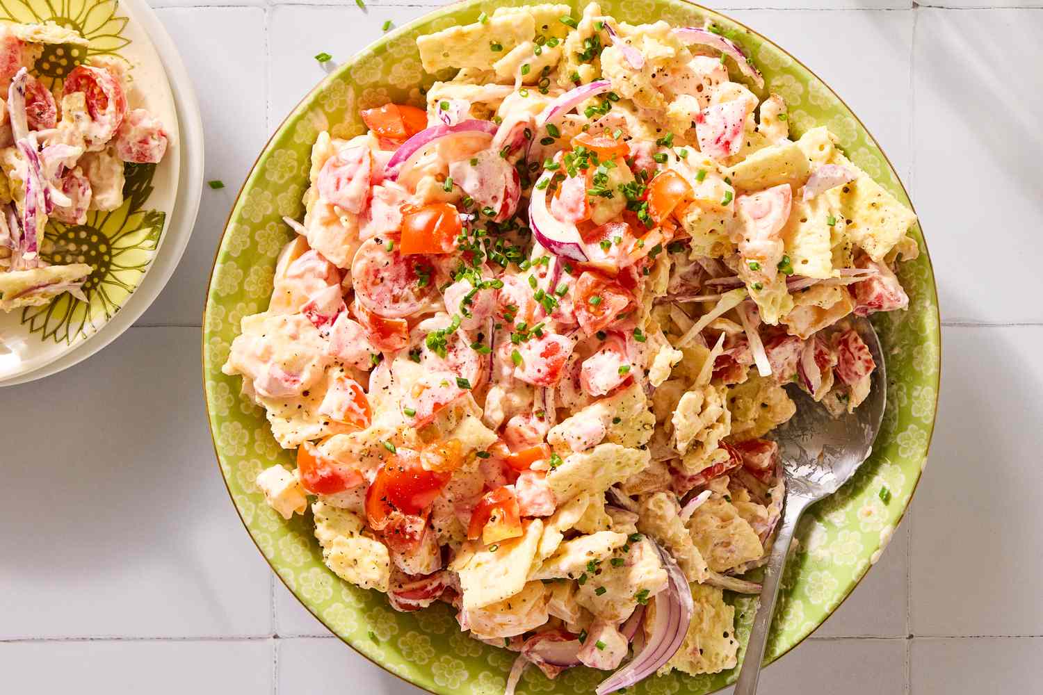 Tomato cracker salad in a bowl with a serving spoon