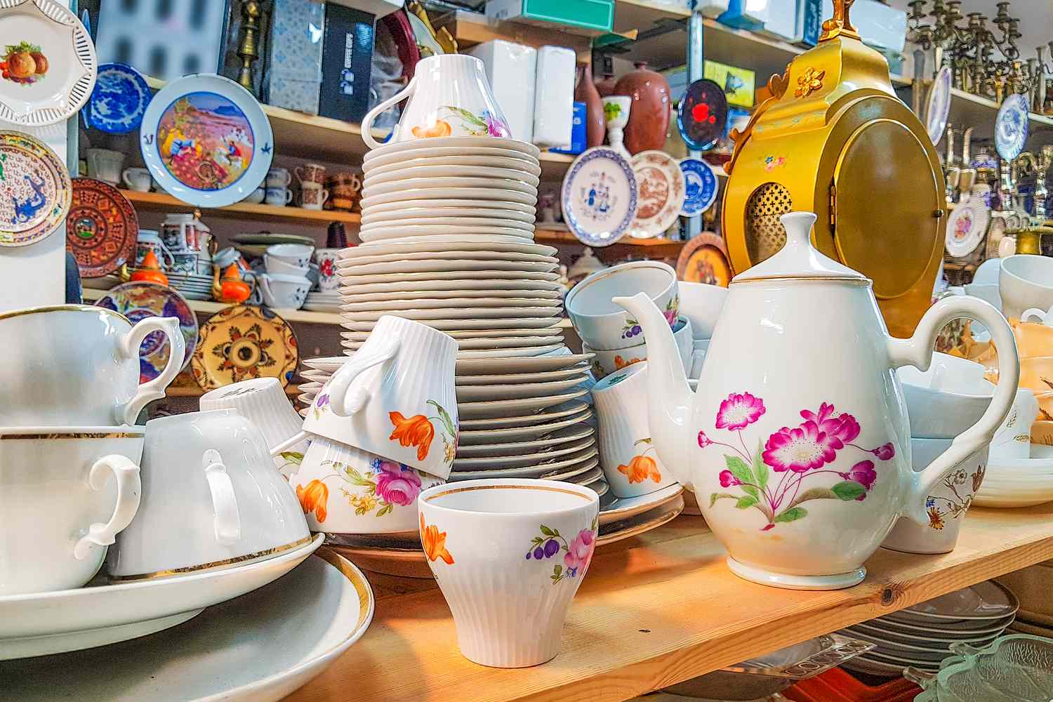 Different used vintage porcelain dishes and other home related objects in flea market second hand shop