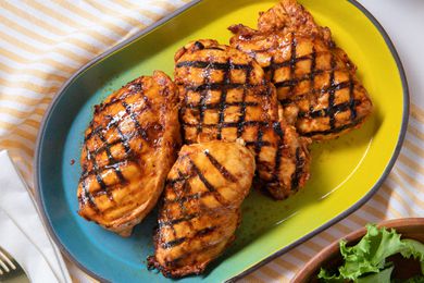 grilled chicken on a platter at a table setting