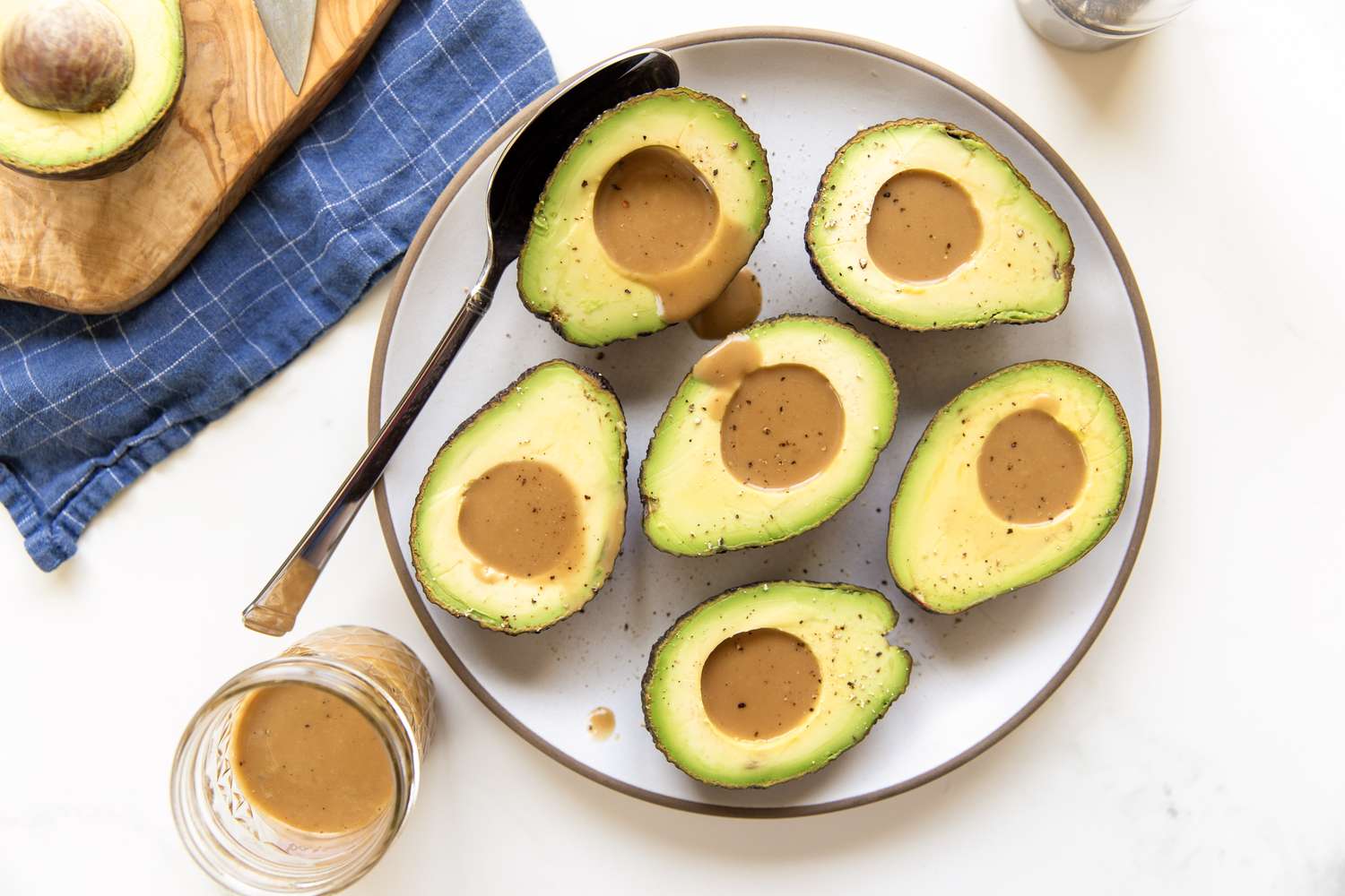 Halved avocados with dressing served on a plate