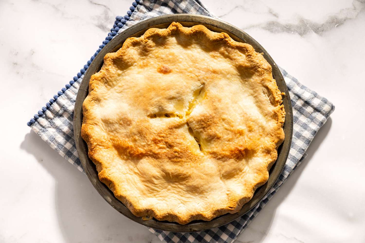 Baked chicken pie in a dish on a checkered cloth