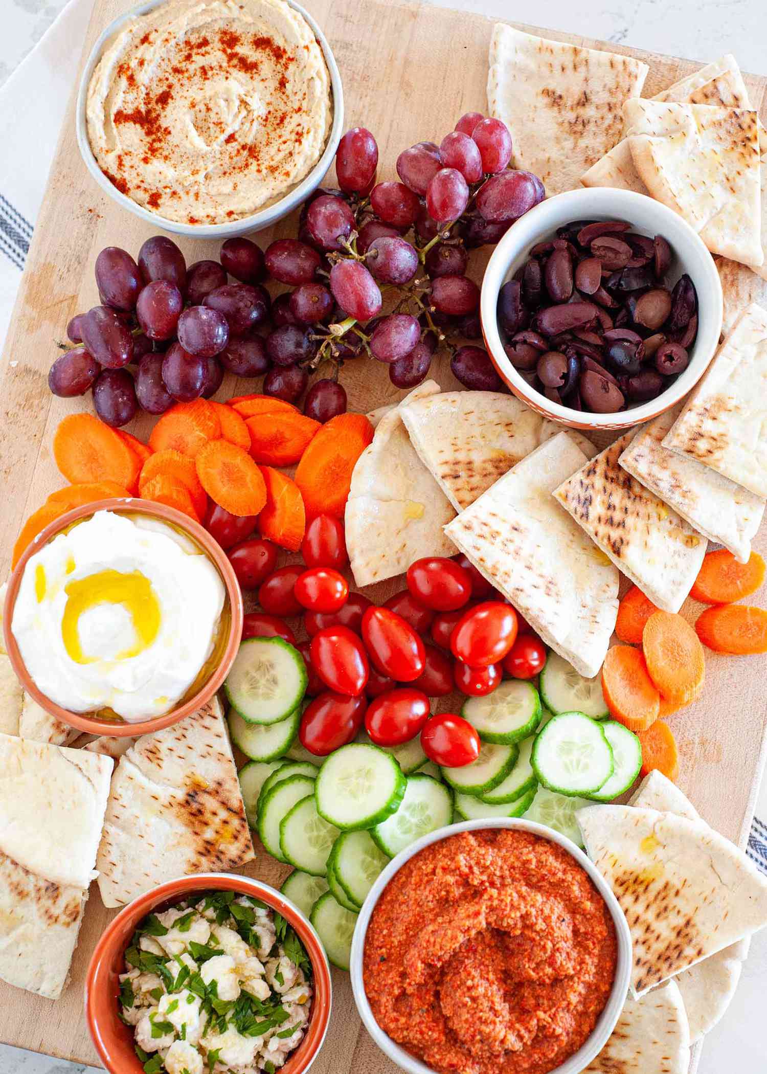 Mediterranean mezze platter with olives grapes vegetables pita