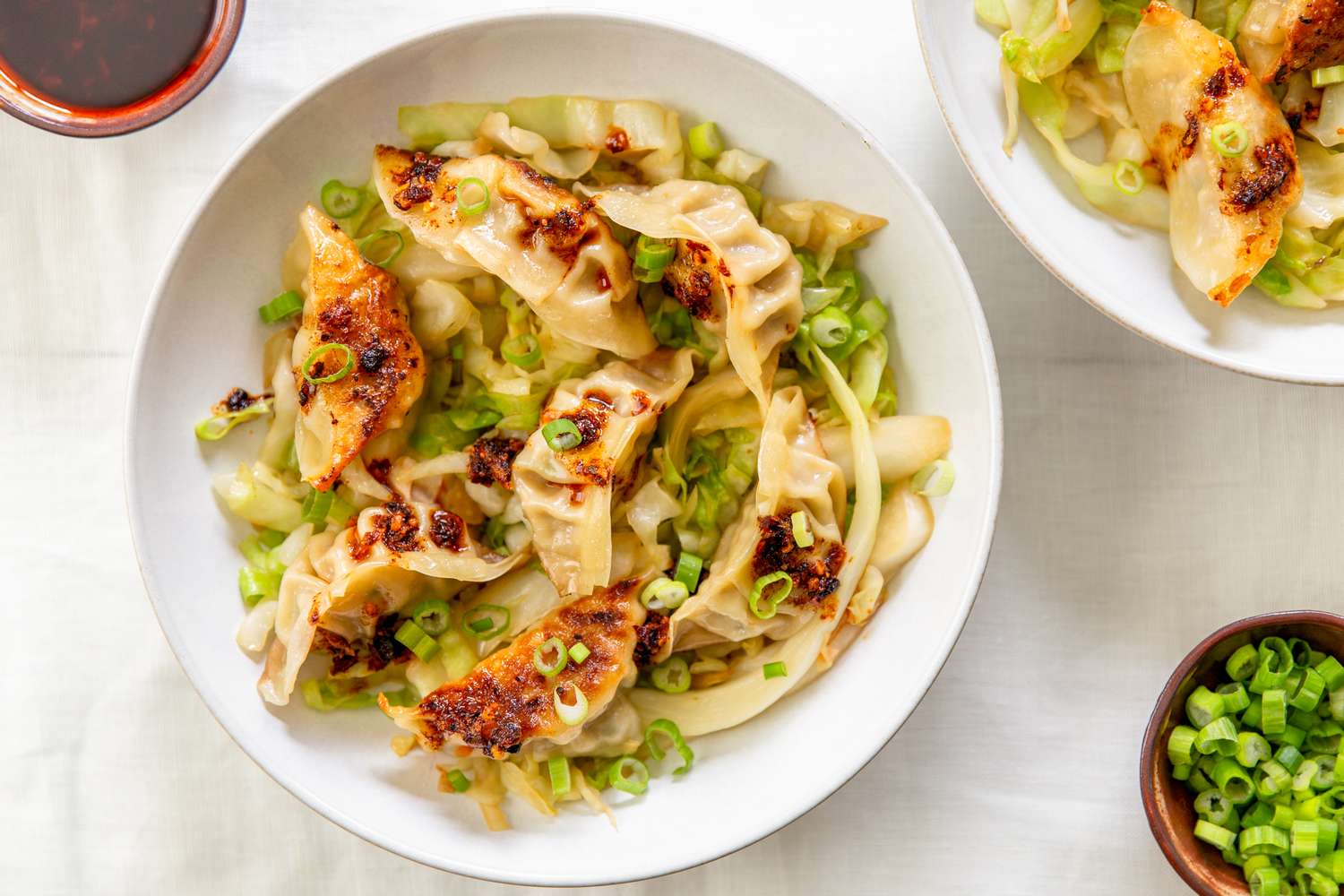 Gyoza served over a bed of shredded cabbage garnished with chopped green onions