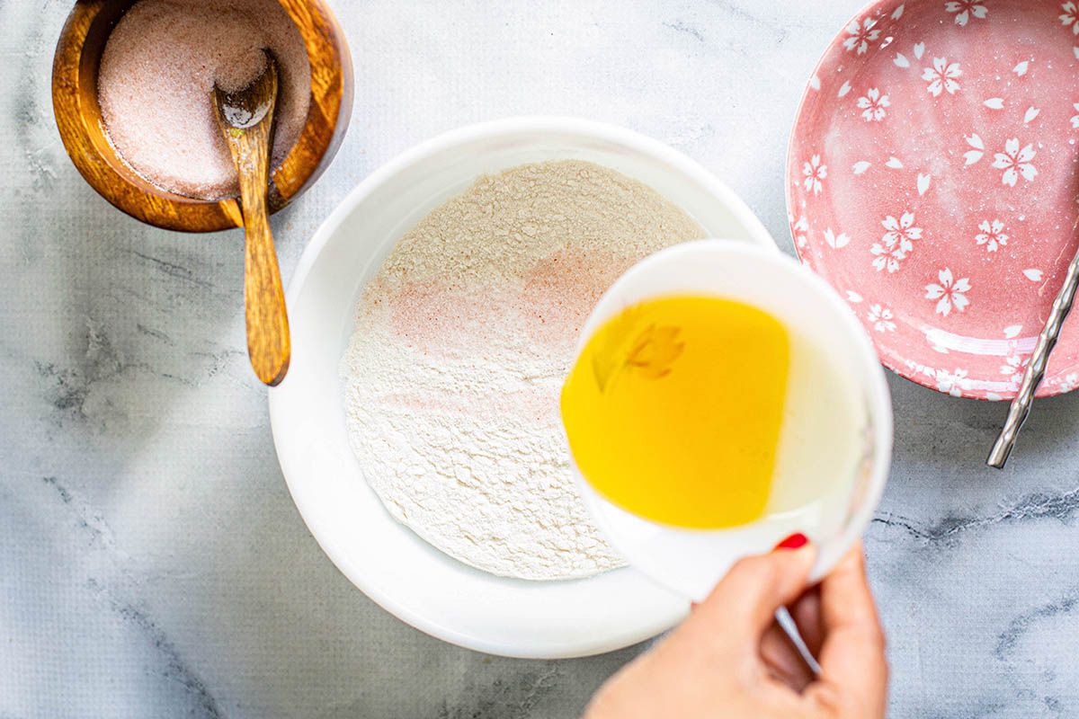 Ingredients to make dough -- flour, slat and butter or ghee in three small bowls on a marble counter.