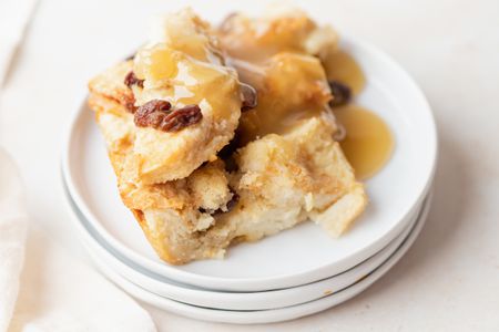 A stack of plates with easy bread pudding set on top.