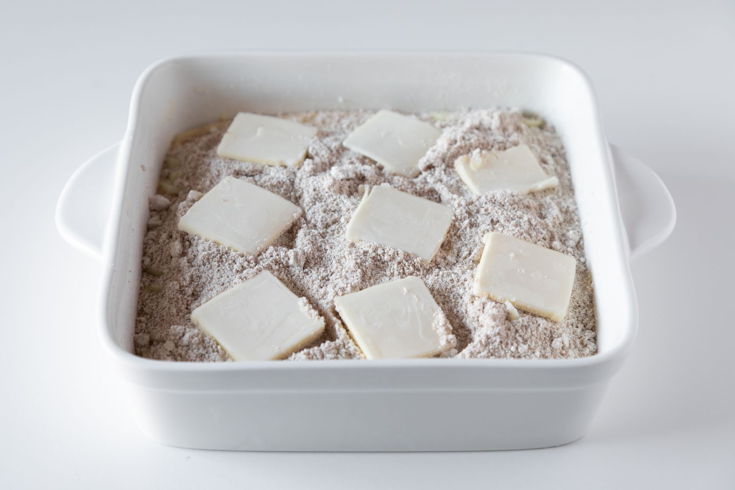 Bisquick apple cobbler in a baking pan and ready to be baked.