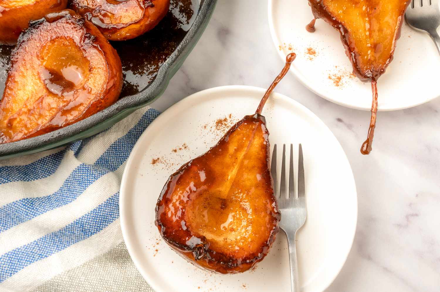 Caramelized pear halves served on a plate with a fork dessert presentation