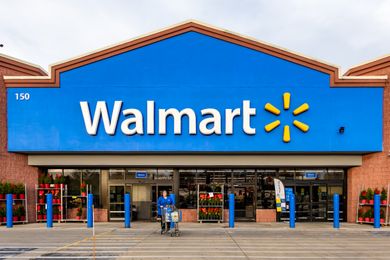 Exterior of a Walmart store with a person pushing a shopping cart in front