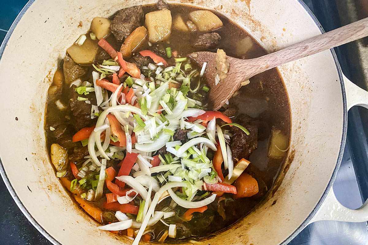 Sliced vegetables added to the pot for Jamaican Stewed Beef.