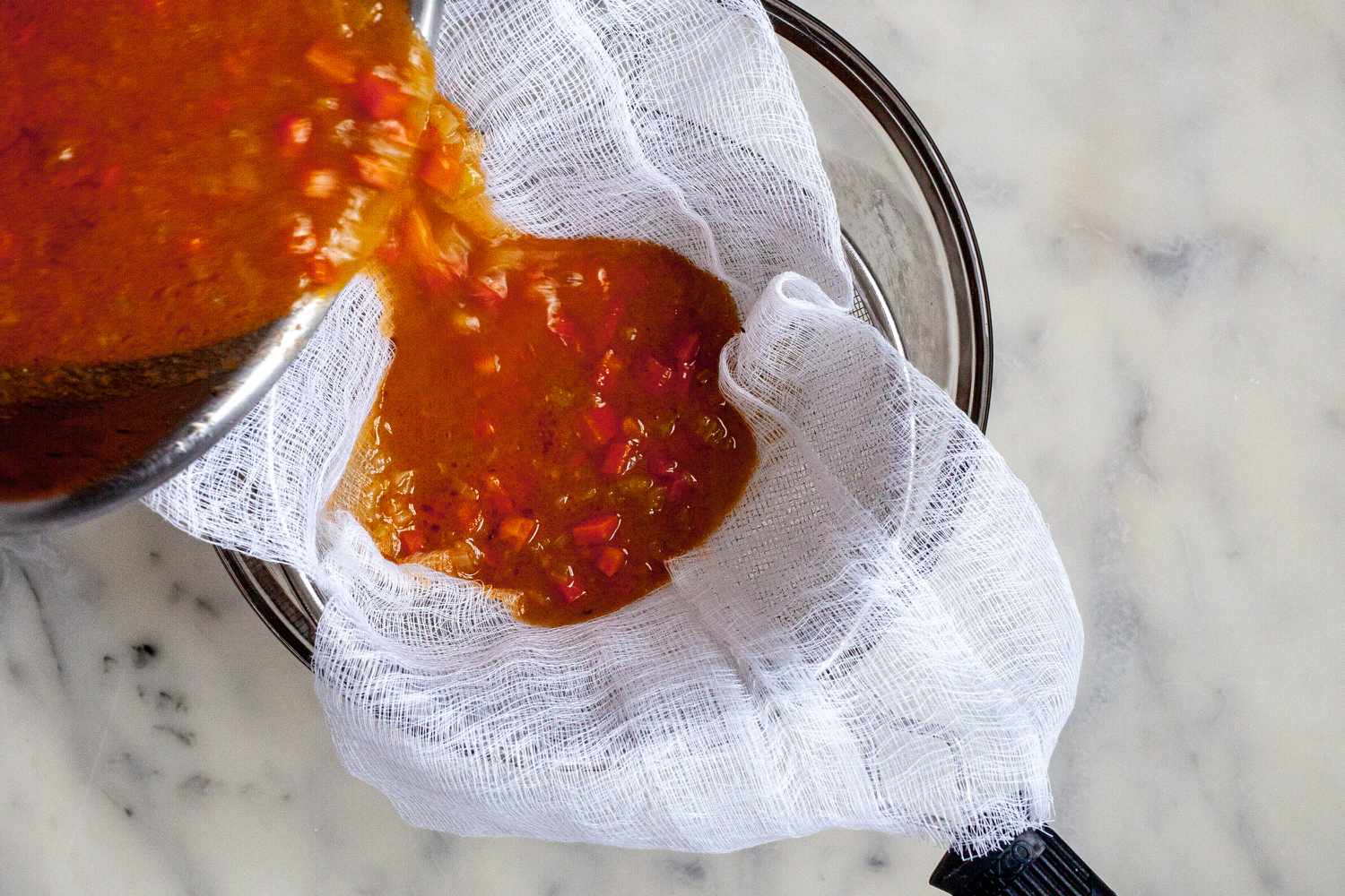 Classic espagnole sauce strained with cheesecloth