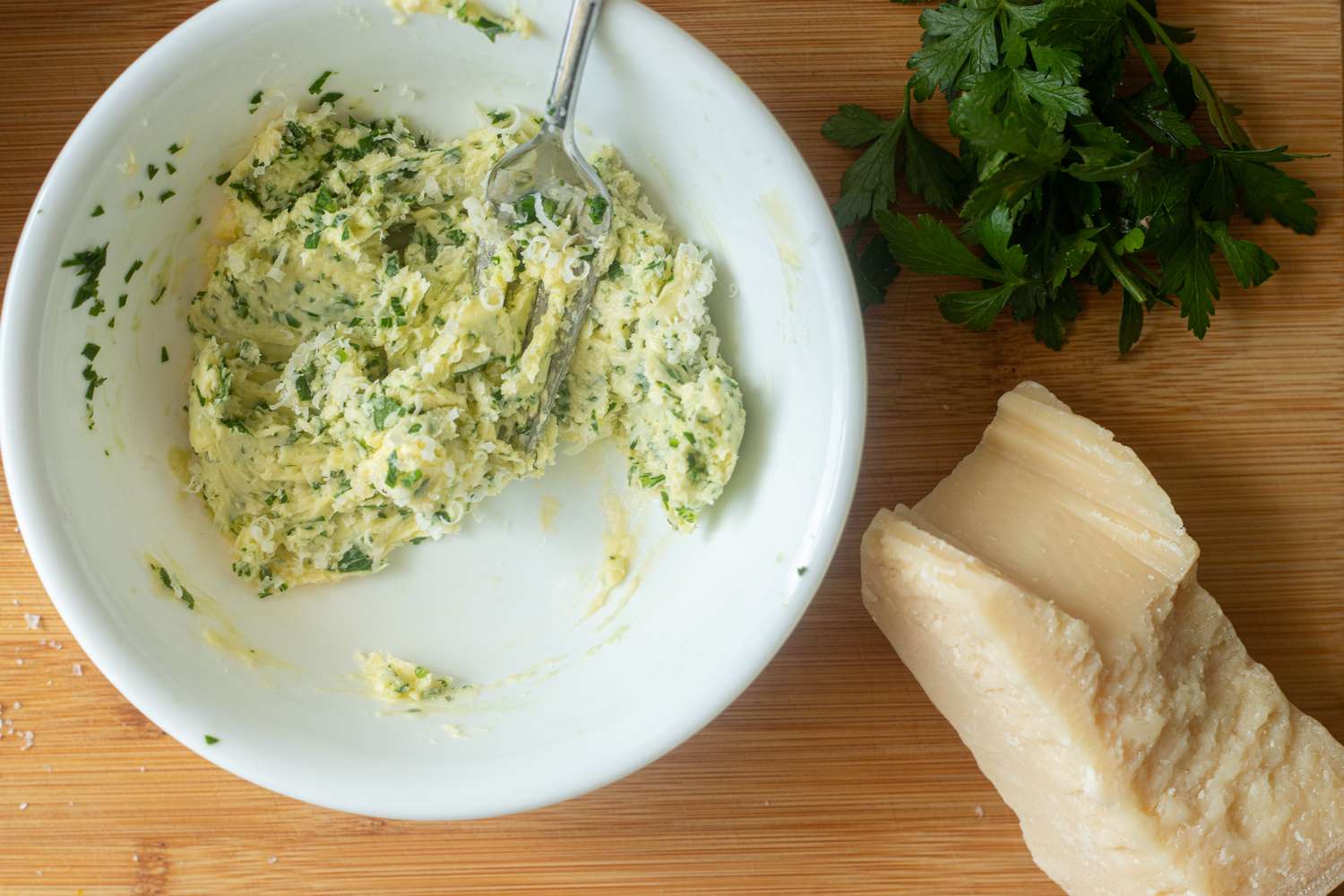 Mixing compound butter for pull apart rolls with garlic and parmesan.