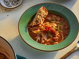 A bowl of tomato, white bean, and fennel stew on a kitchen counter