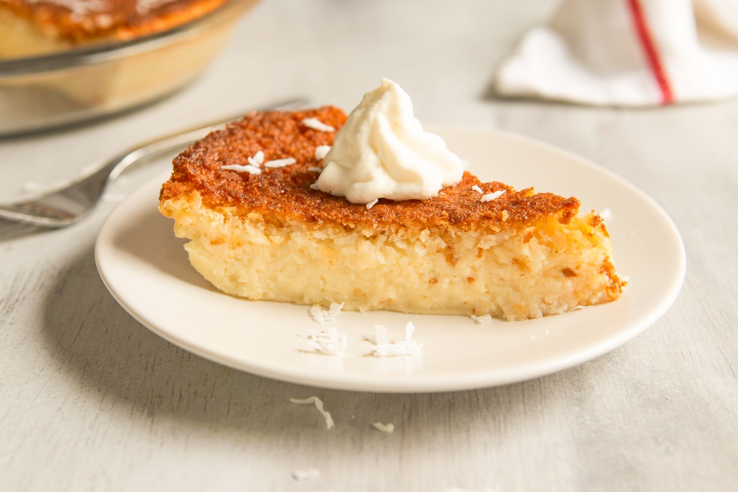 A slice of pie topped with whipped cream on a white plate