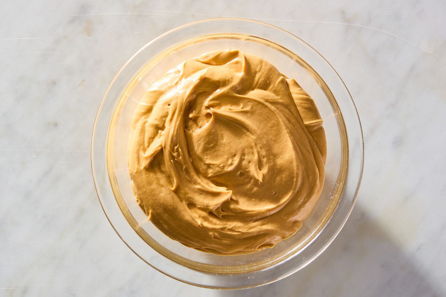 Frosting for the Easy Jam Cake in a clear bowl