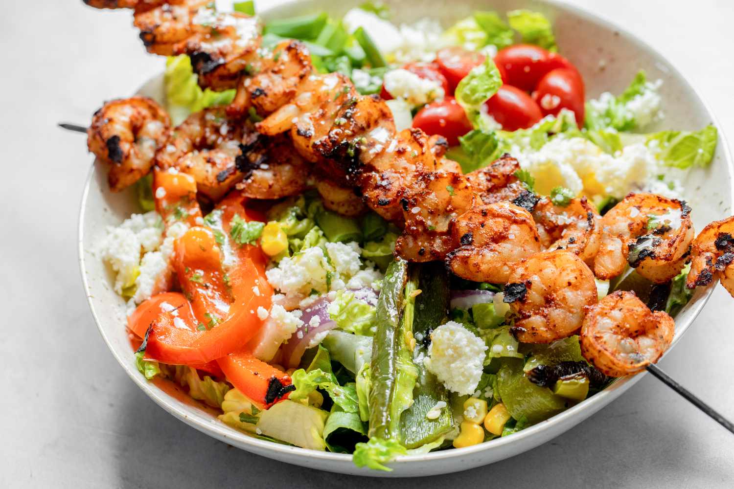 Bowl of Grilled Shrimp Salad with Shrimp on Skewers