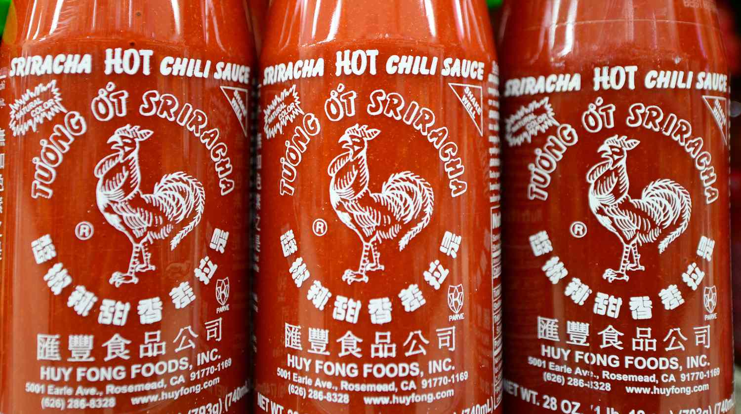 Close up of three bottles of Huy Fong sriracha showing the rooster on the label