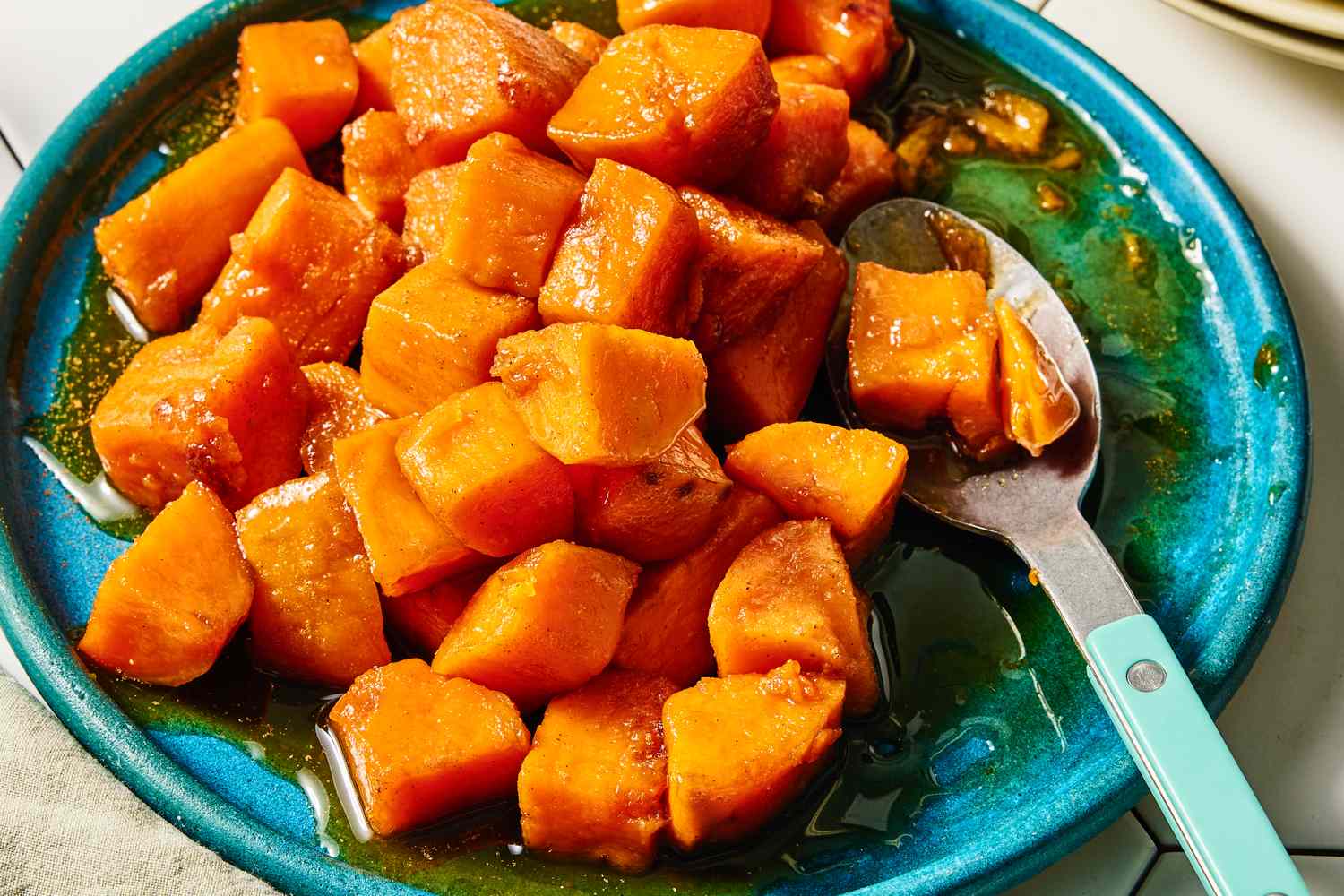 A plate of candied yams served with a spoon