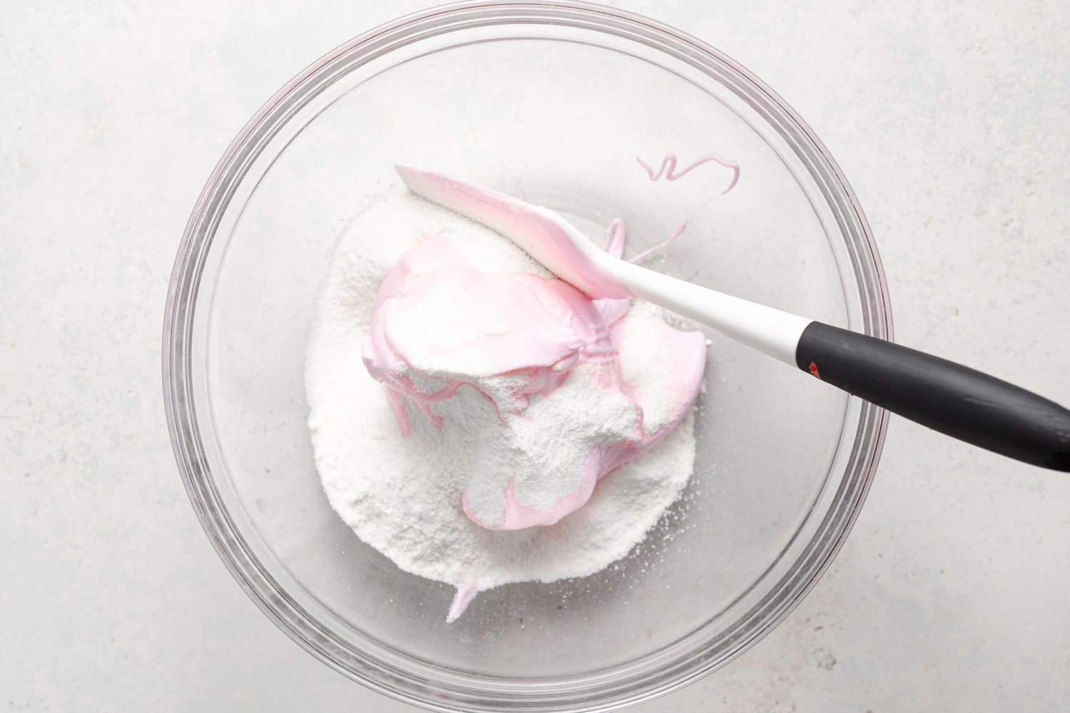 Mixing pink meringue in with dry ingredients to make strawberry macarons.