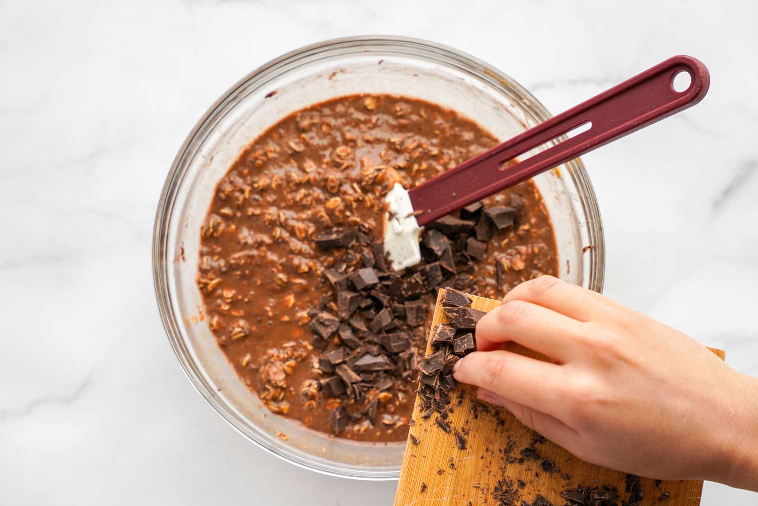 Chopped Chocolate Added into the Bowl of Vegan Brownie Baked Oatmeal Batter