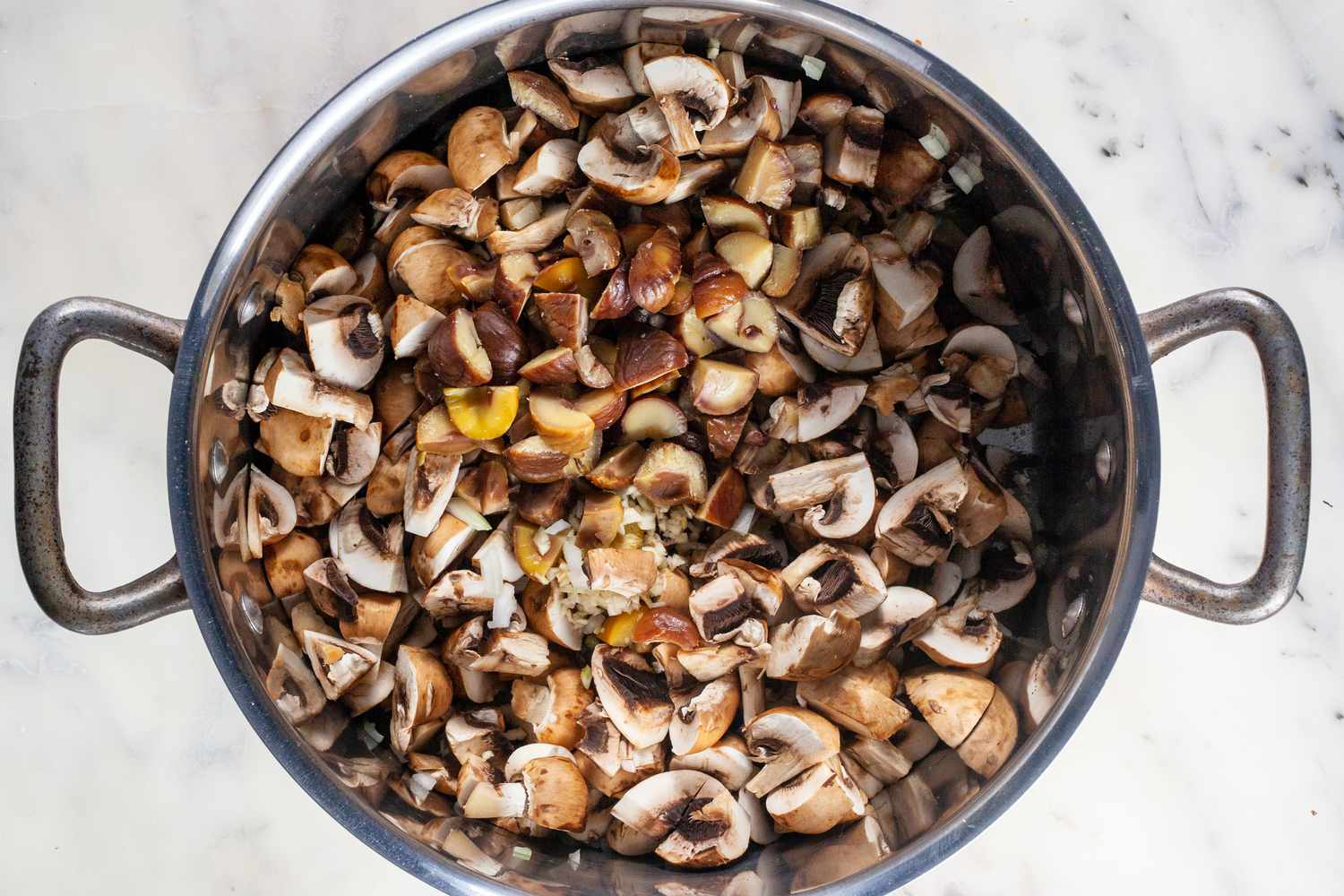 Mushrooms in a large stockpot to make creamy chestnut and cremini soup