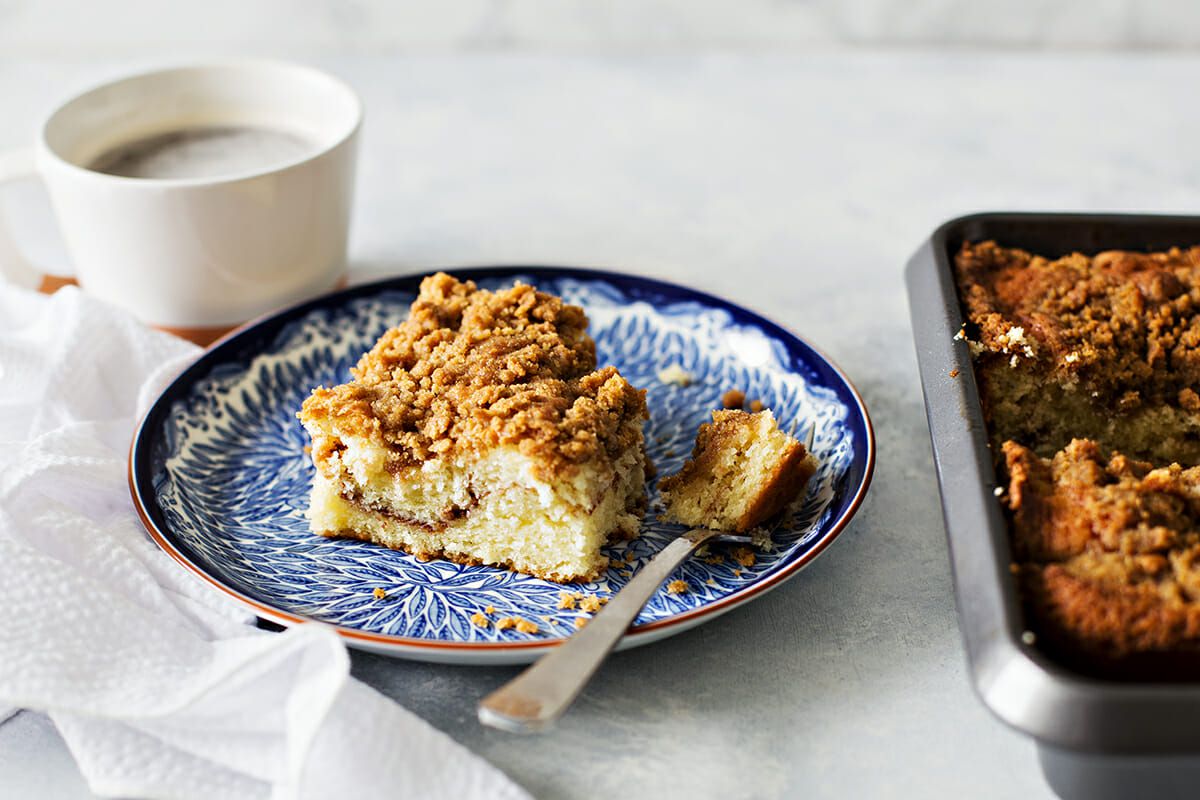 Cinnamon Coffee Cake on a plate with a cup of coffee off to the side