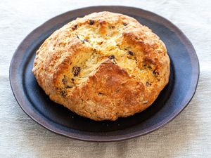 A loaf of Irish Soda Bread with raisins on a plate