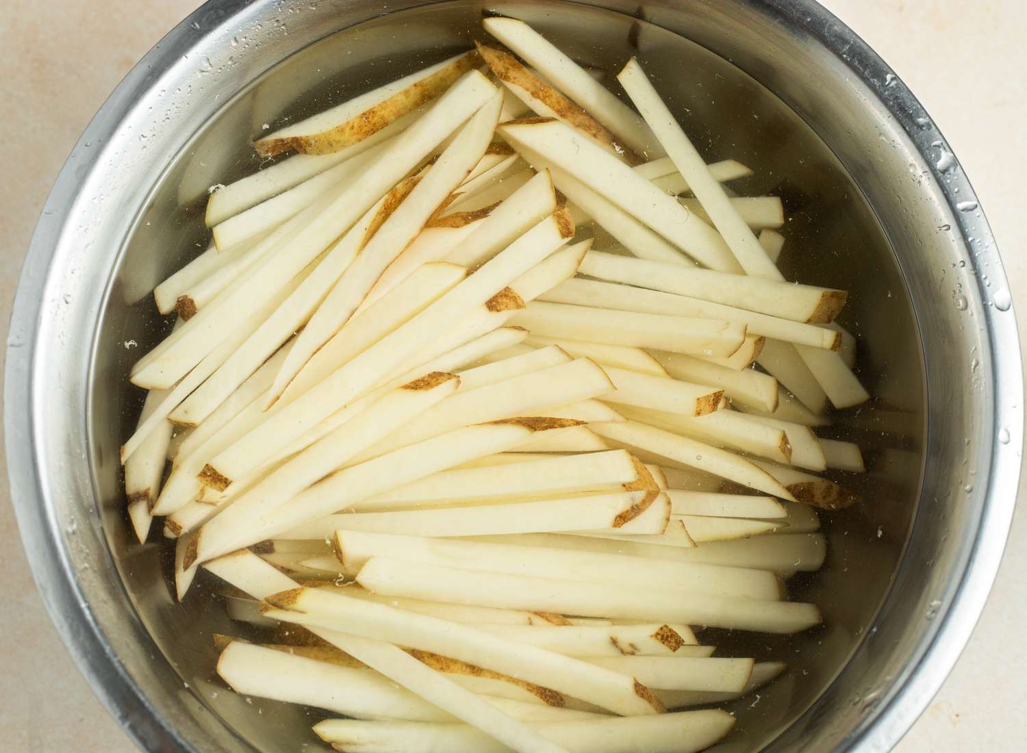 Homemade French Fries Soaking in Bowl of Water 