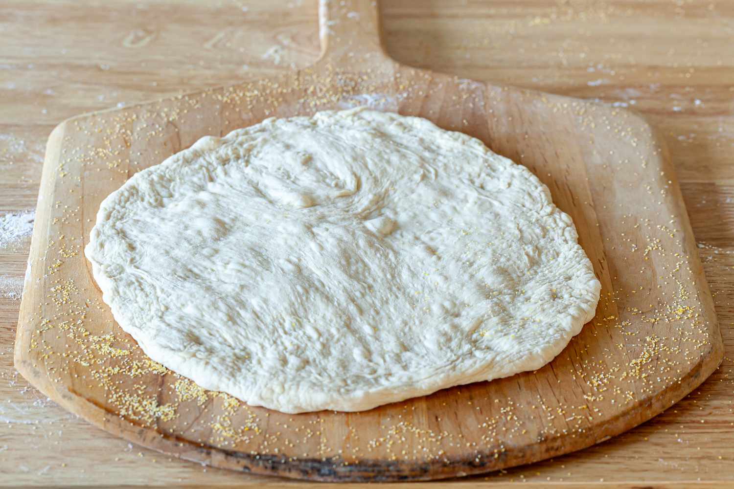 Showing how to make pizza dough and place on a pizza peel.