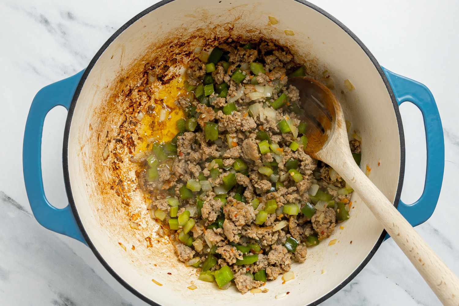 Onions, Celery, and Peppers Stirred into Cooked Sausage in Dutch Oven for Dirty Rice With Shrimp Recipe