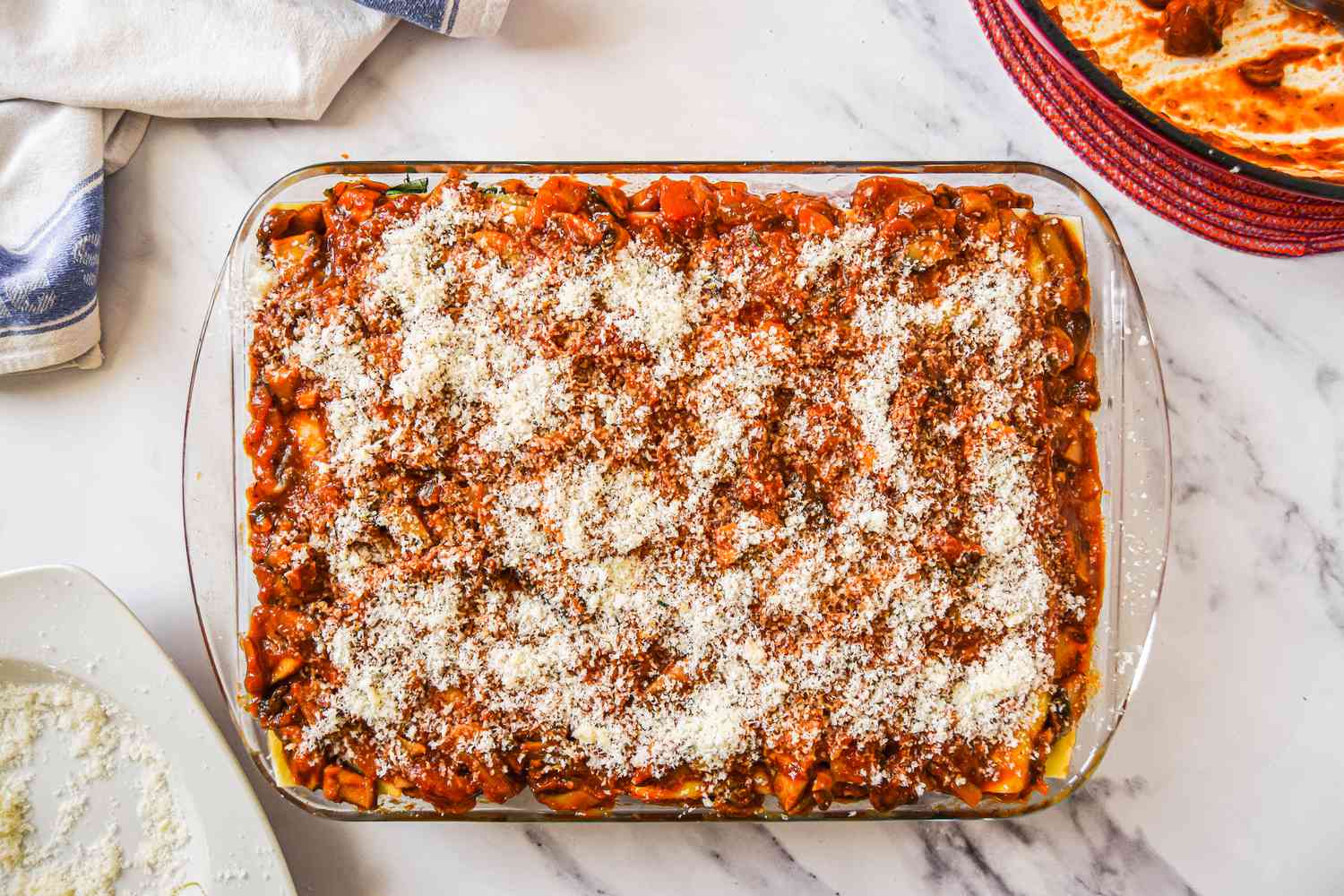 The Last Layer of Sauce and Cheese Added to Casserole Dish lasagna 
