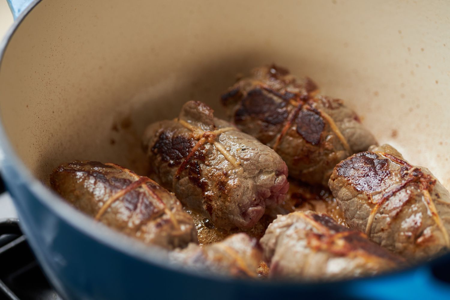 Rouladen seared in a Dutch oven until deep brown
